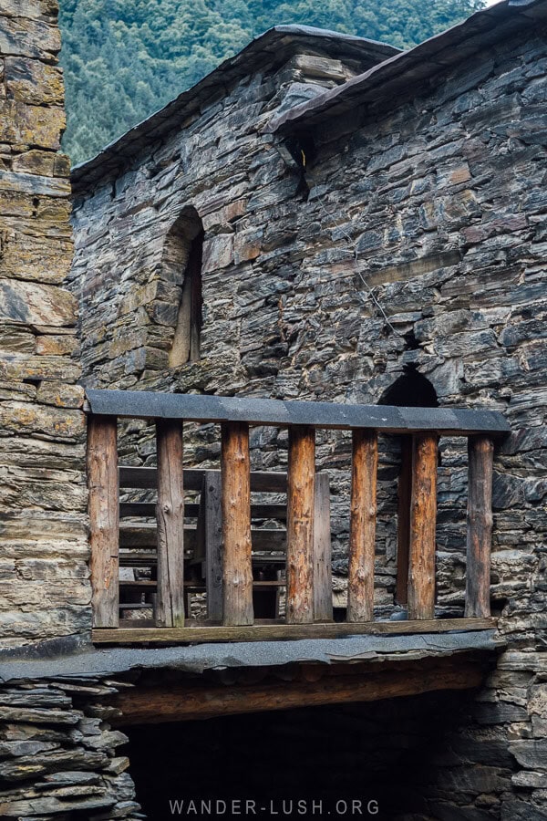 A wooden bridge connecting stone tower houses in Shatili, Georgia.