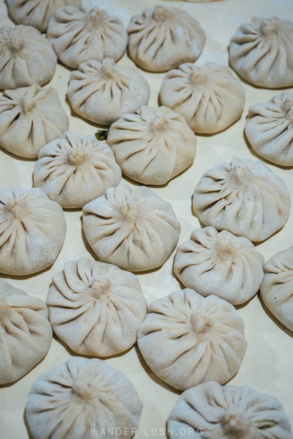 A table covered with homemade khinkali dumplings ready to be cooked.