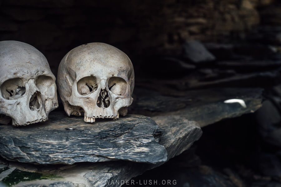 Skulls on a stone ledge inside a burial crypt in Khevsureti.