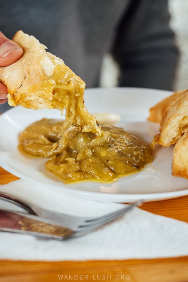 A man dunks Georgian shoti bread into dambalkharcho aged cheese at a restaurant in Pshavi, Georgia.