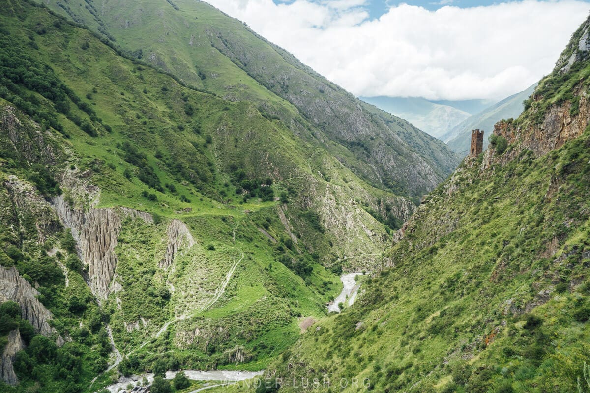 A deep river gorge in Mutso, Khevsureti with a lone stone watchtower on the edge.