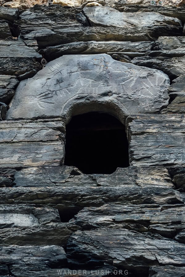 Pictograms engraved in stone above a window on a stone tower house in Shatili, Khevsureti.