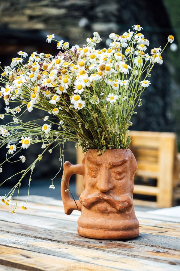 A clay vase of flowers on a restaurant table in Shatili, Georgia.