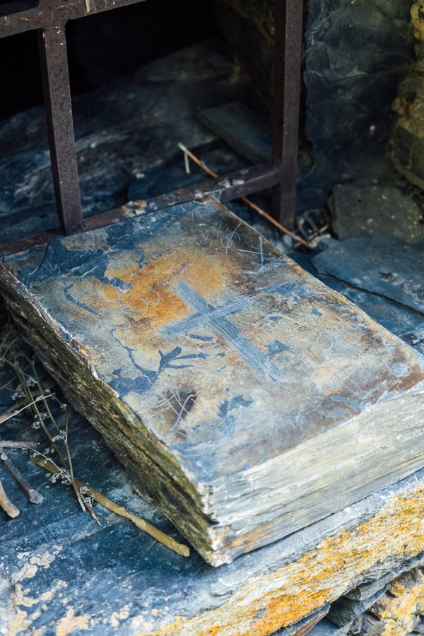 A stone tablet engraved with a cross sits on a windowsill at the Anatori Burial Chambers in Khevsureti, Georgia.