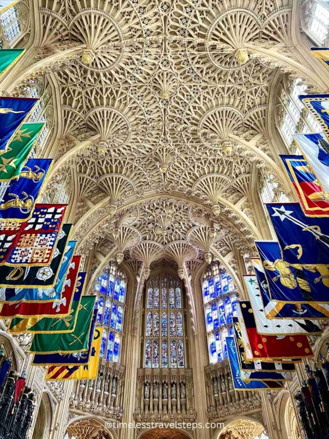 Image of the entrance to the Lady Chapel at Westminster Abbey, adorned with the standards of the Knights of the Order of the Bath and a stunning vaulted fan ceiling. The beautiful and grand design creates a special, awe-inspiring atmosphere.
