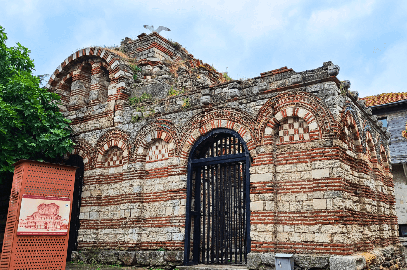 Side view of St Michael and Gabriel the Archangels church which is made in the same typical red and white stone style of many of the churches in Nessebar.