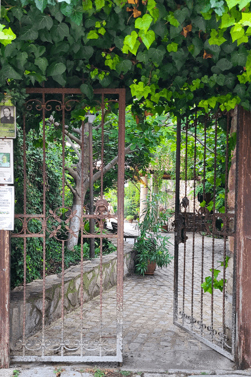 Gated entry into the church walls of Dormition of Theotokus in Nessebar with a picturesque stone path.