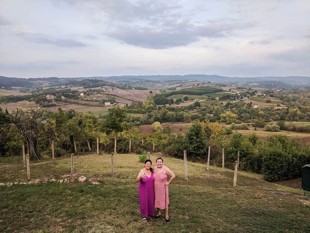 Riana and her mom posing in front of the rolling hills of Tuscany, Italy