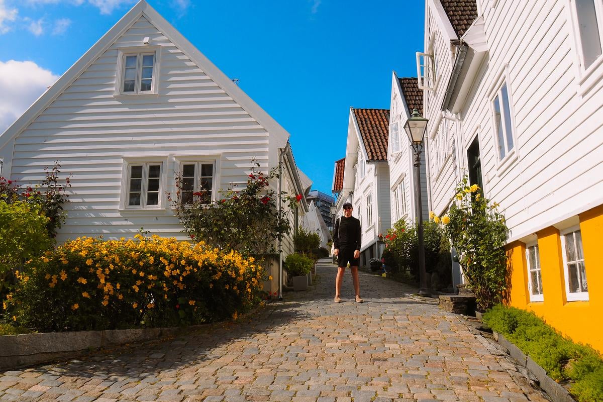 Charming cobblestone street in Old Town Stavanger, Norway, with white wooden houses and flowers