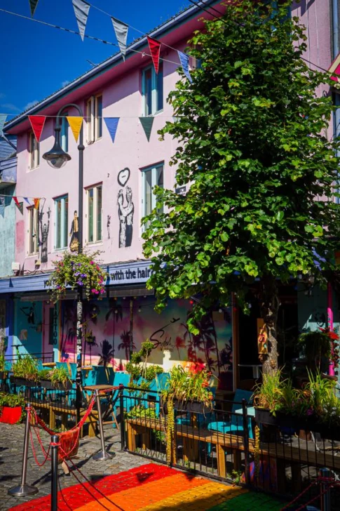 Colourful street scene in Fargegaten, Stavanger, Norway with vibrant murals and outdoor seating