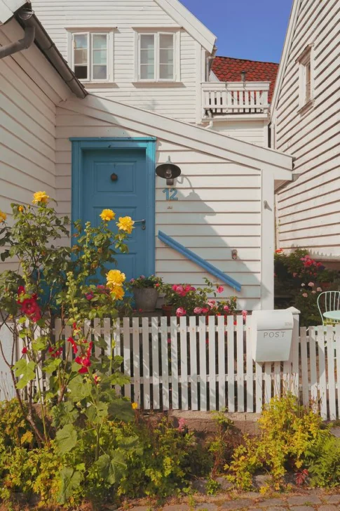 Cute white wooden house with colorful garden in Old Stavanger, Norway