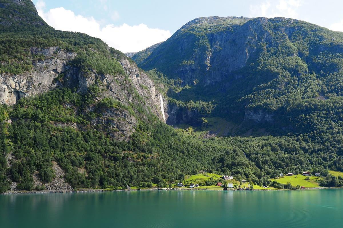 Feigumfossen Waterfall in Sognefjord, Norway with lush green mountains surrounding