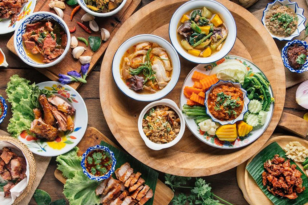 Over the top view of traditional Northern Thai food on a wooden table.