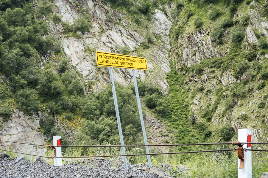 A yellow sign reading Landslide Section in Georgian and English.