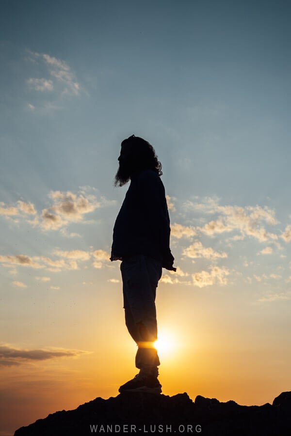 A man stands in front of the setting sun in Bakhmaro, Georgia.