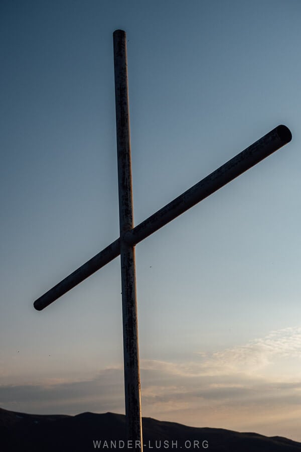 A big cross marks the top of a hill for viewing the sunset in Bakhmaro, Georgia.