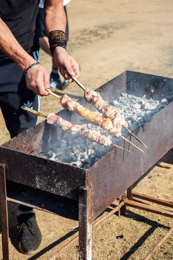 A man cooks mtsvadi Georgian BBQ on a grill in Bakhmaro.