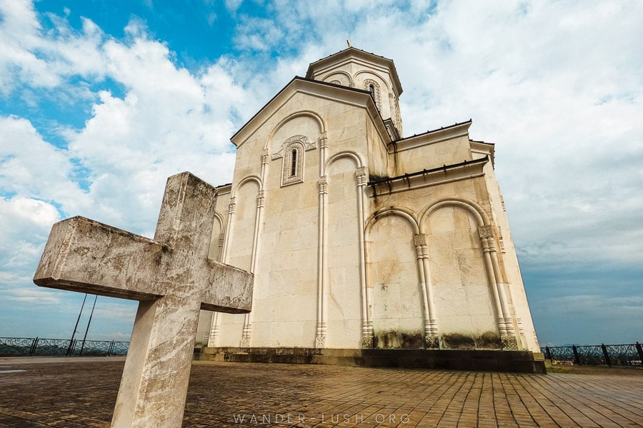 The white stone Ekadia Church of Saint George, with a cross out front.