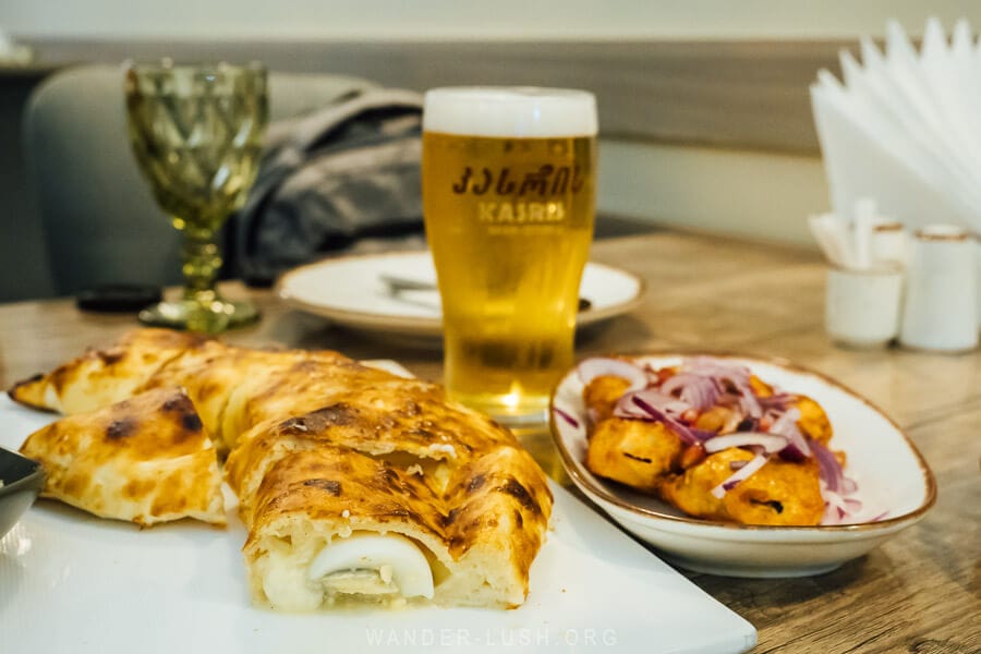 Gurian khachapuri and other Georgian foods on a restaurant table in Ozurgeti.