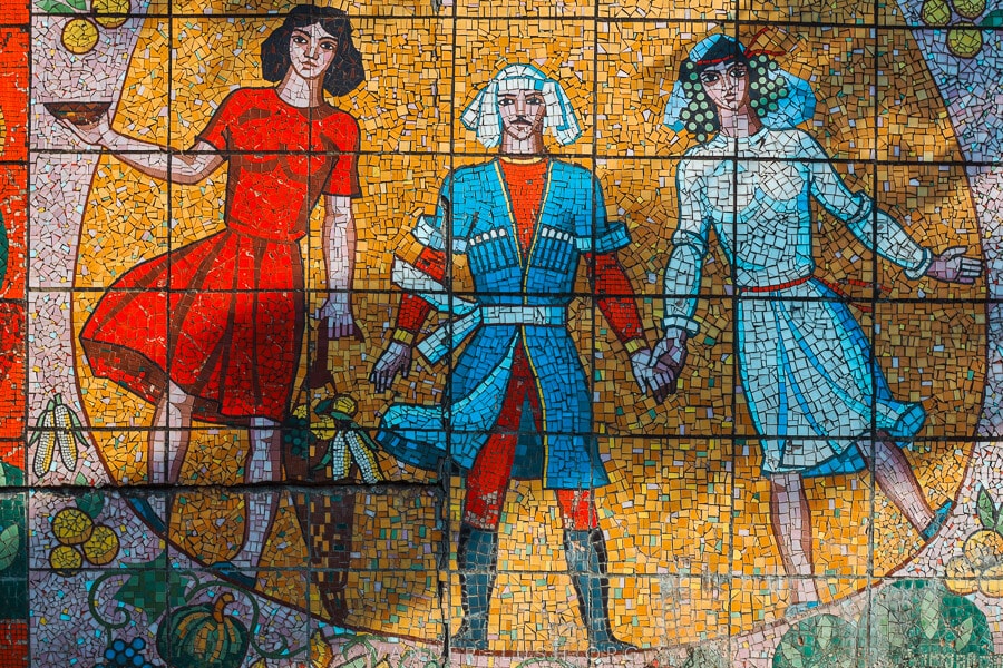 A Soviet mosaic in Shroma, Guria depicts three people in traditional dress holding hands.