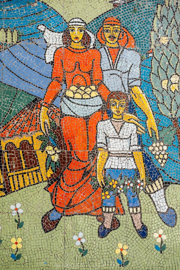 A mosaic depicting two workers and a child in a village in Georgia.