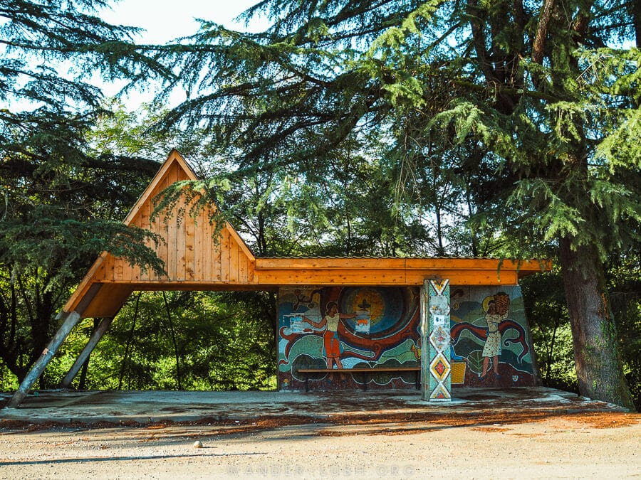 A distinctive bus stop in Guria, with a peaked wooden roof and a Soviet-era mosaic underneath.