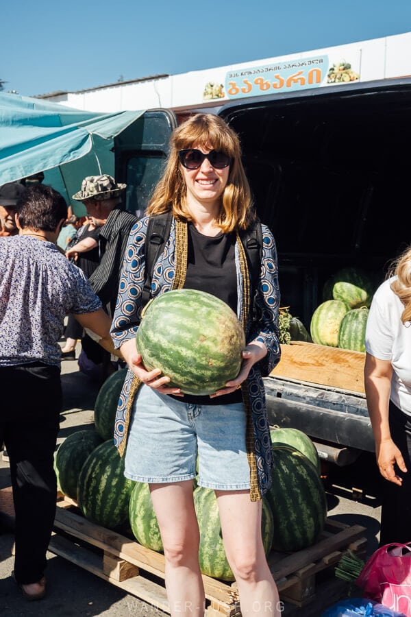 Emily holding a watermelon at a farmers market in Georgia.