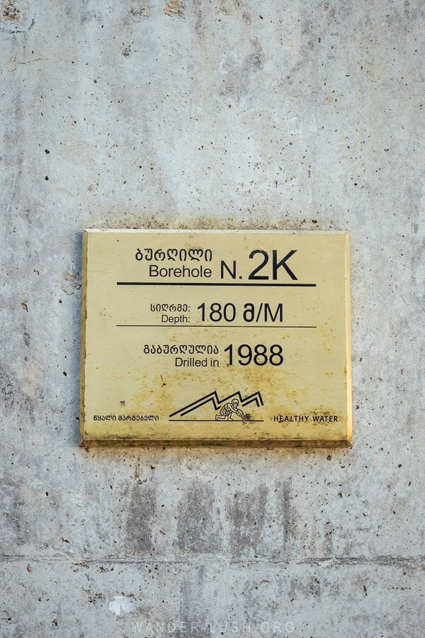 A gold sign marks a mineral water borehole in Nabeghlavi, Georgia.