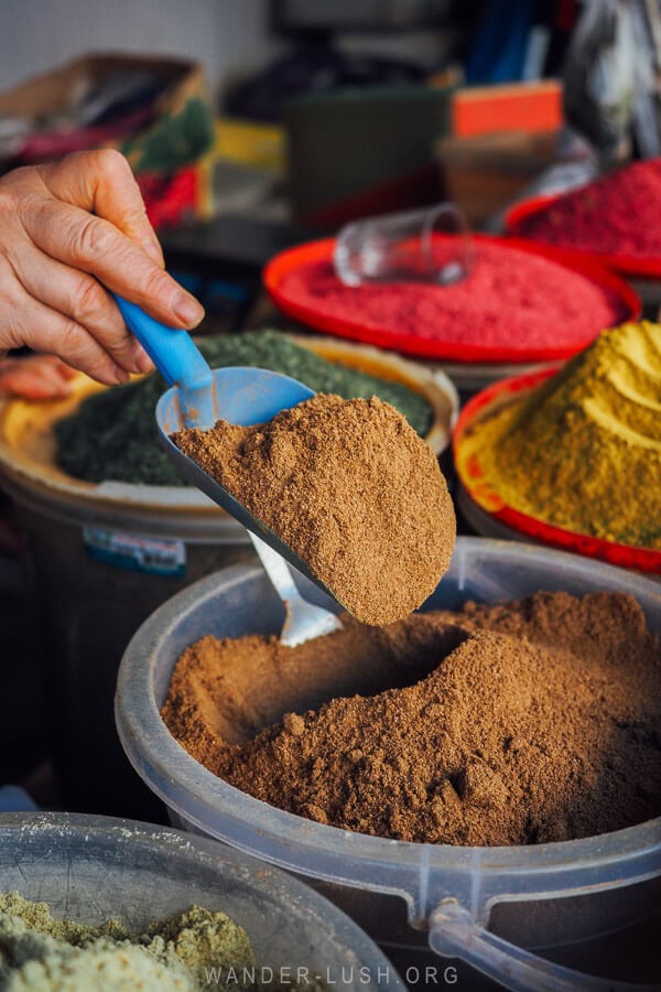 A woman raises a spoon of Georgian spice at the Dezerter Bazaar in Tbilisi.