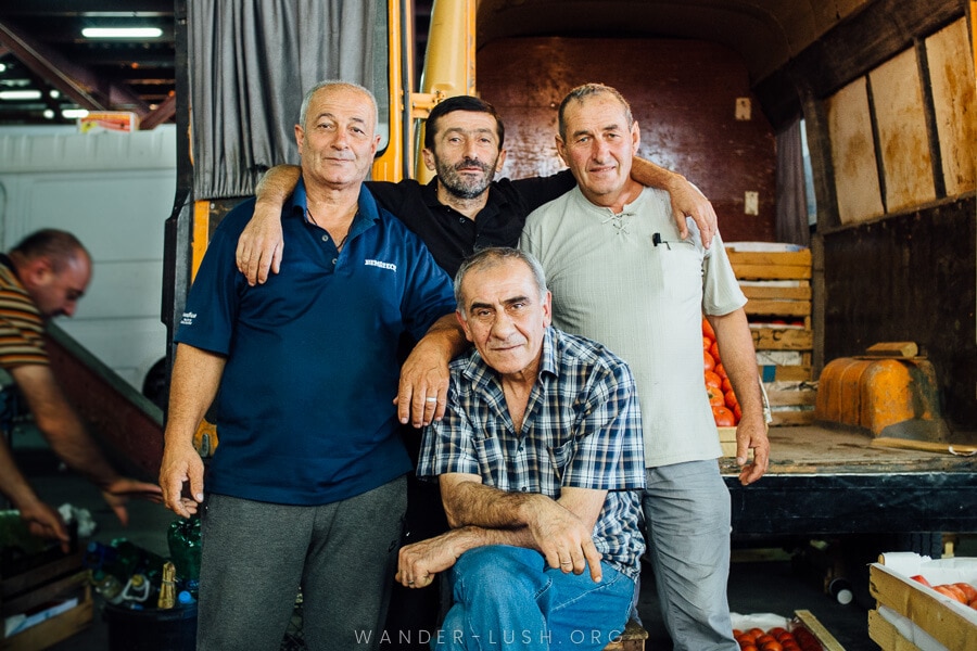 A group of four men pose for a photo.