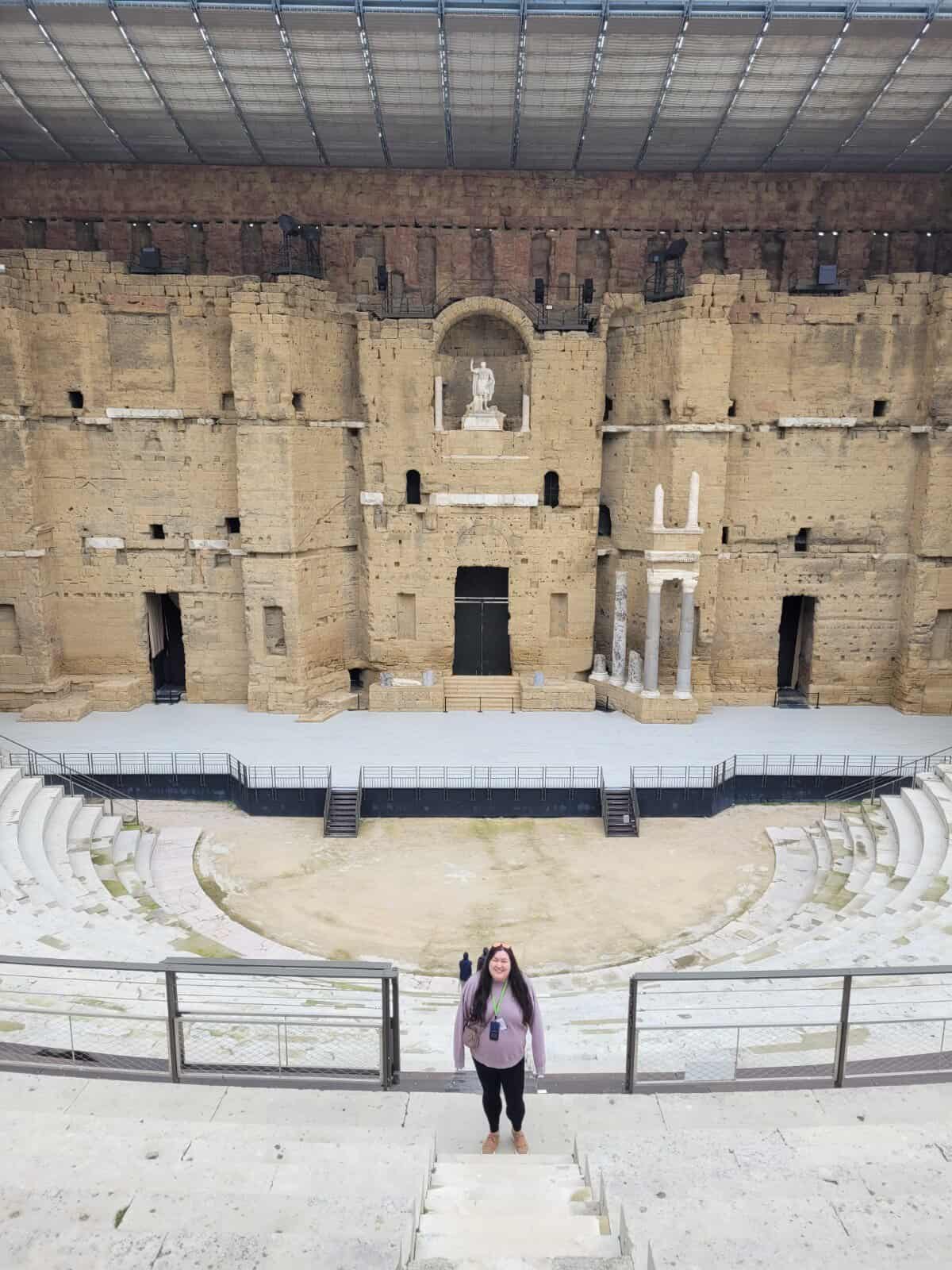 Riana standing along the tiered marble stands at the Roman Theatre Orange France 