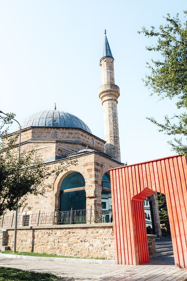 Iliaz Bej Mirahori Mosque, an old mosque with a grey-blue minaret in Korca, Albania.