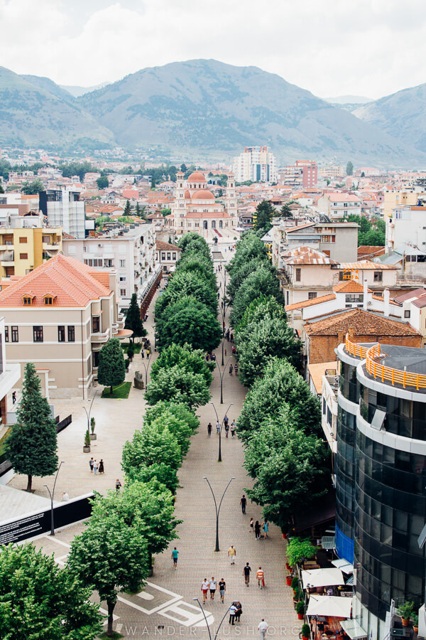 A tree-lined pedestrian street in Korca, Albania.