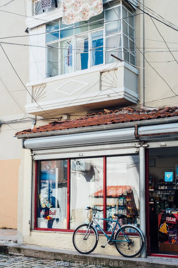 A little shopfront with a bicycle parked out front in the city of Korca in Albania.