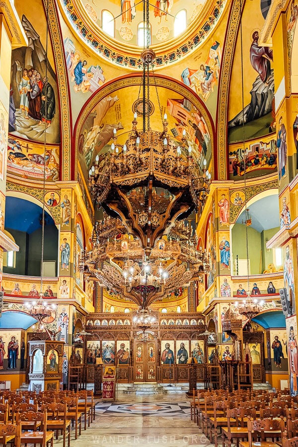 Icon paintings inside the Cathedral of Korca, with a huge chandelier hanging from the dome.