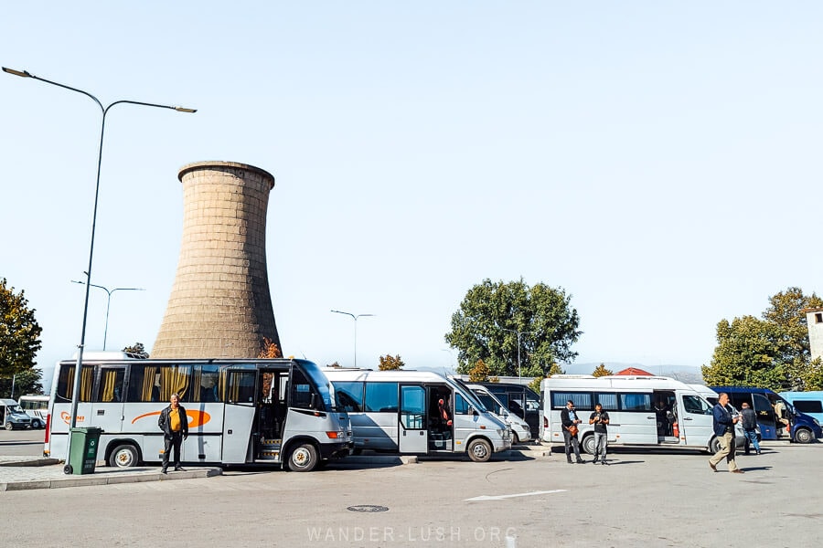 Furgon minibuses wait in queue in front of a smokestack at the bus station in Korca, Albania.