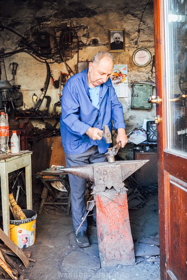 A blacksmith hammering hot metal inside his workshop in the Korca Old Bazaar in Albania.