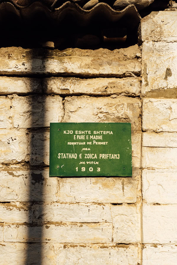 A sign reads 1903 on the front of an old house in Permet, Albania.