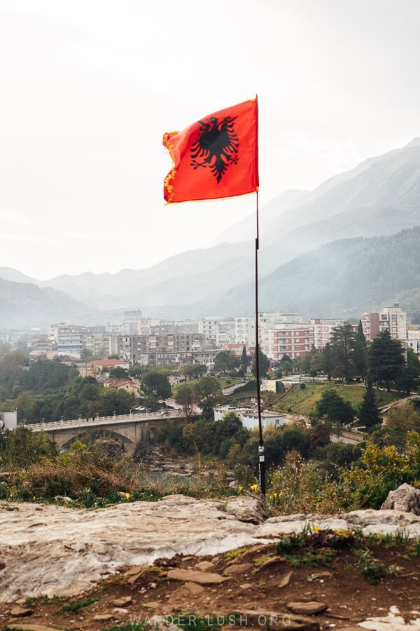 An Albanian flag blows in the wind on the top of the City Stone in Permet.