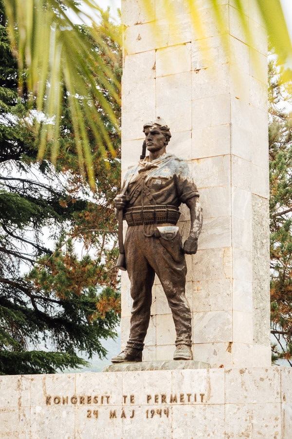 The Permet Congress Statue, a tall concrete monument with a sculpture of a soldier.