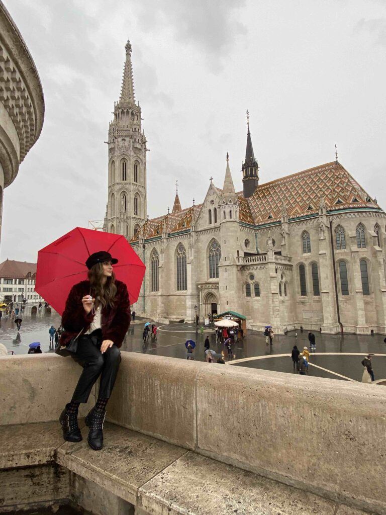 Woman holding a red umbrella on a rainy day in Budapest