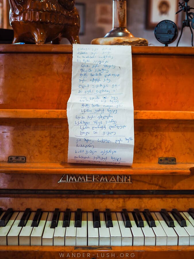 A piano with a long composition on white paper.