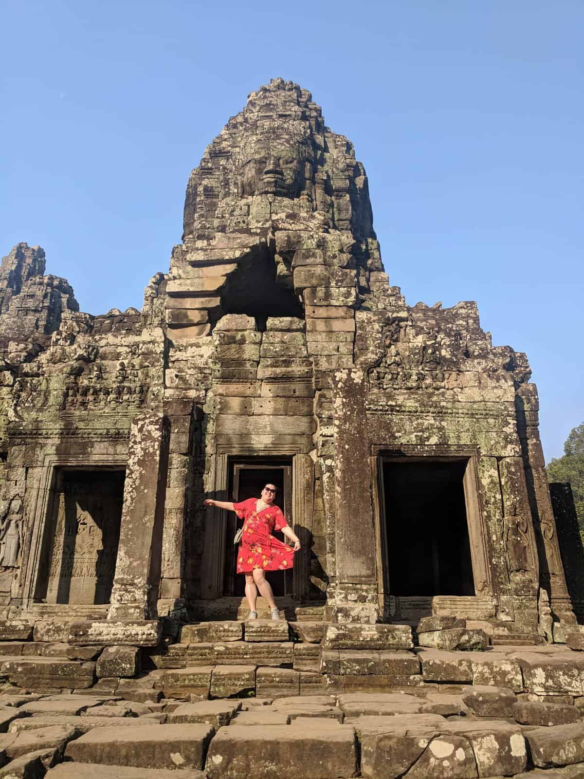 Riana posing in a red dress in front of the temples of Angkor Wat, Cambodia