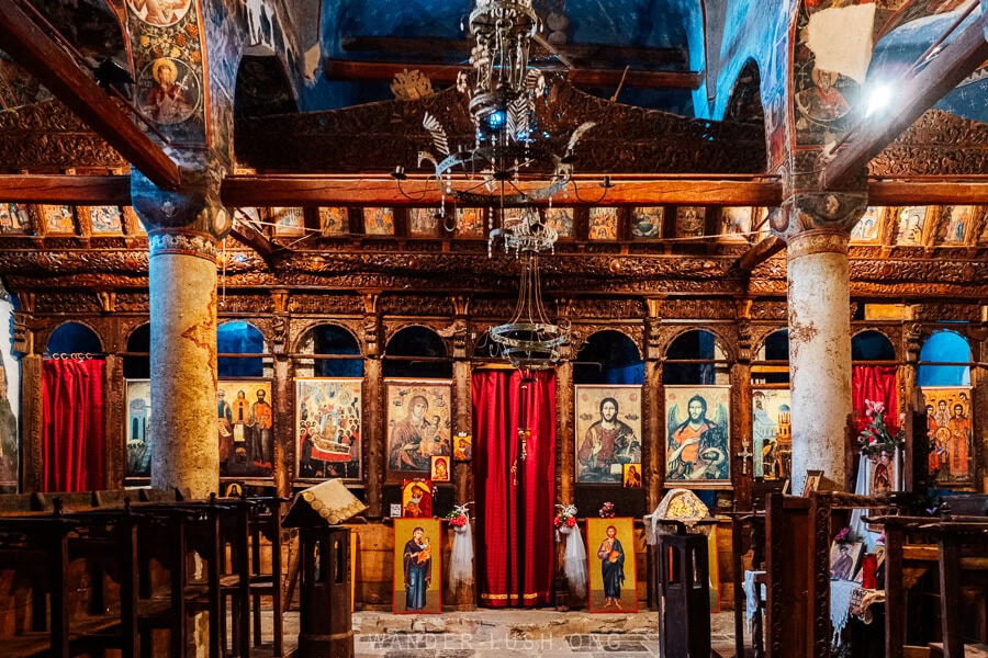 The iconostasis inside the church of Leus, a beautiful altarpiece carved from wood with a red curtain.