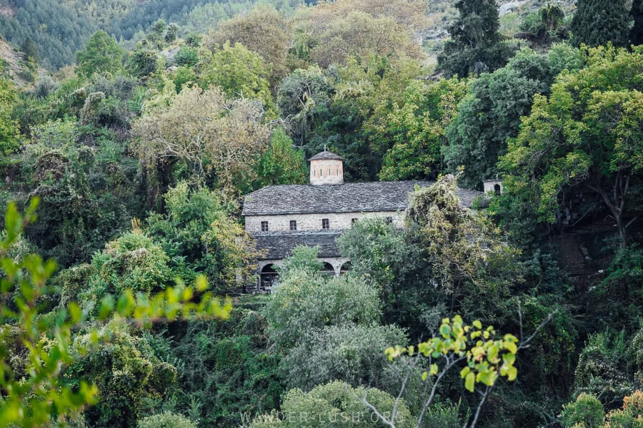 The Church of Leus, a stone Orthodox church in Albania, appearing in the centre of a forest.