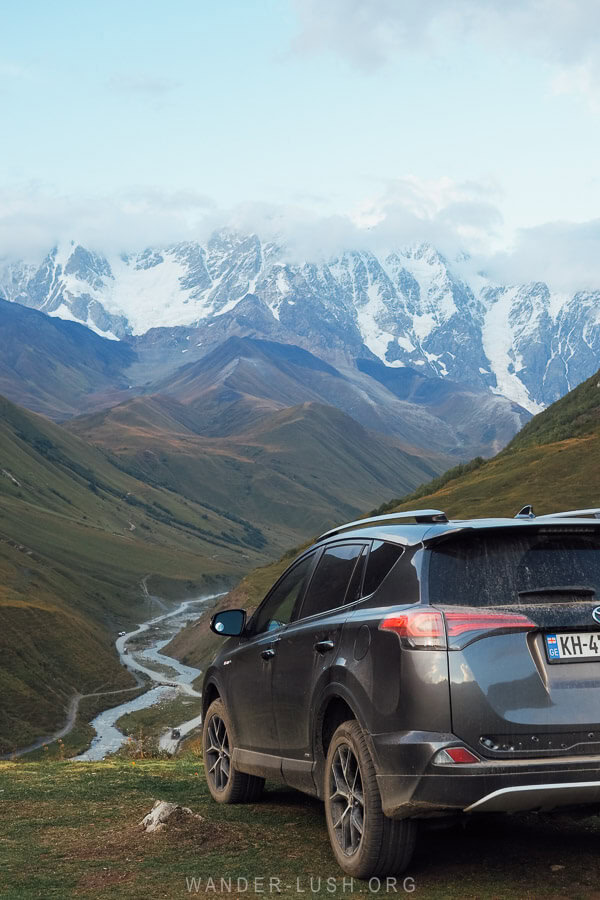 A car parked at a viewpoint overlooking the Enguri Valley in Ushguli.