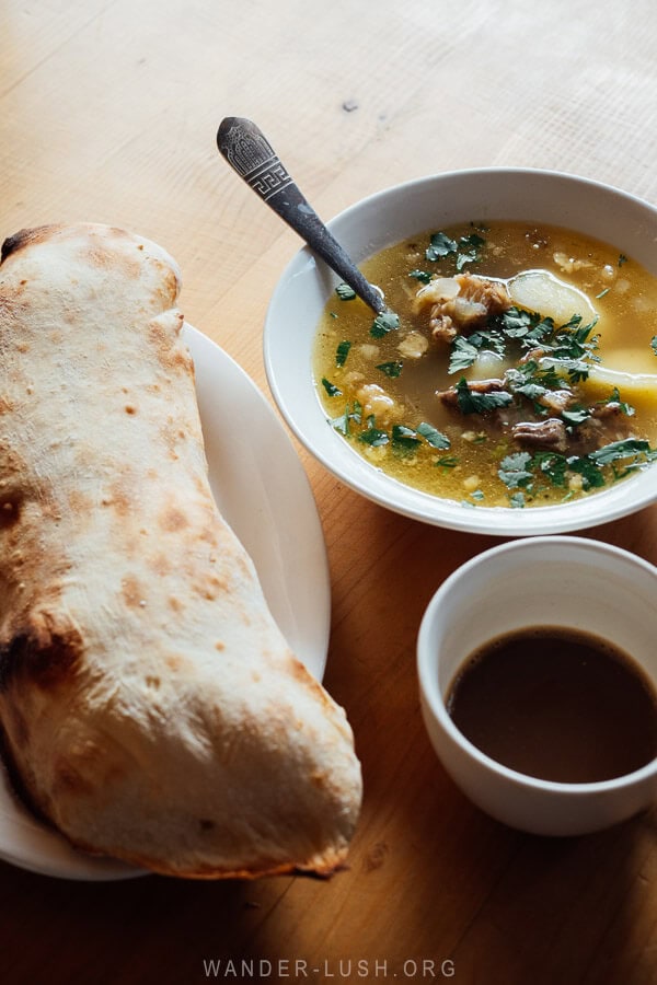 A bowl of soup and a piece of fresh-baked bread on a cafe table in Ushguli, Svaneti.