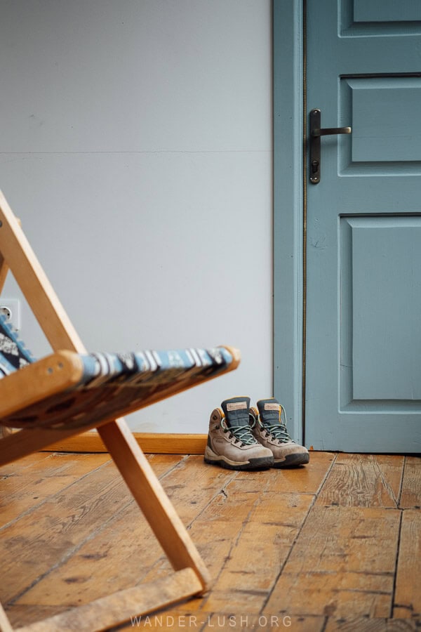 A blue door and deck chair with a pair of hiking boots on the deck at JorJinn Guest House in Georgia.