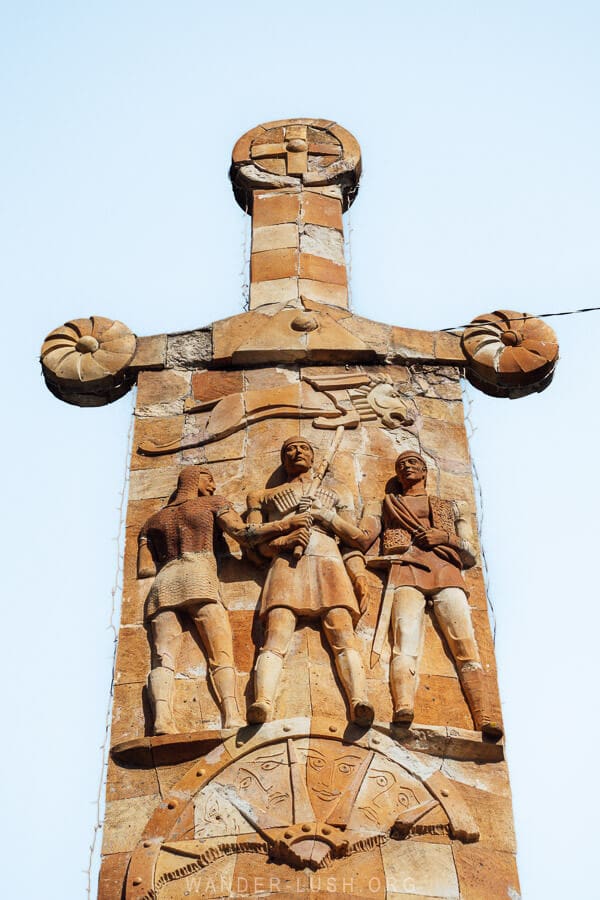 A giant sword monument in Lentekhi, Georgia, with Soviet-style bas-relief details.