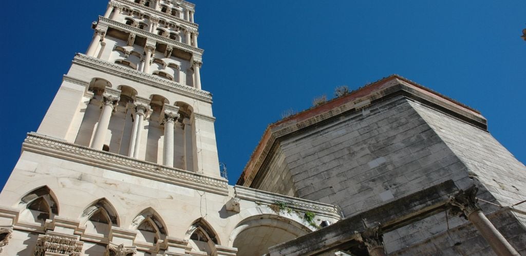 view from below of palace in Split old town, blue sky above 